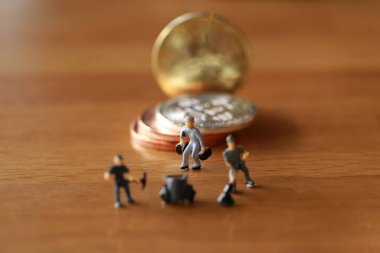 Mühendislik işçisi para kazıyor ve iş ve endüstri konsepti olarak para ile çalışıyor. Altın, gümüş, bronz madeni para ile para kazanmak için çok çalışmak gibi.