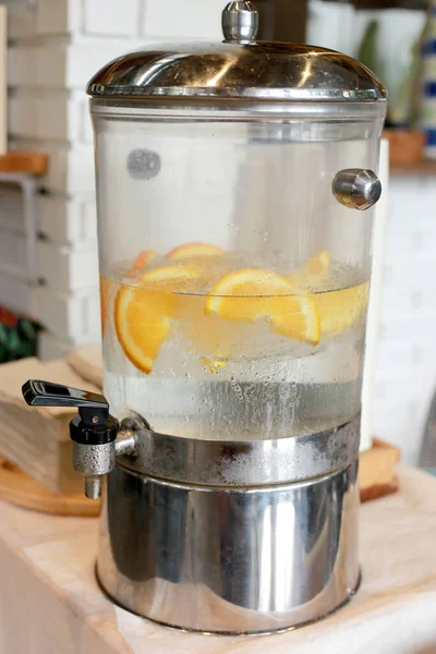 Orange infusion in cold water and ice in big tank for fresh and cool water. Good beverage and healthy drink. Infusion lemonade