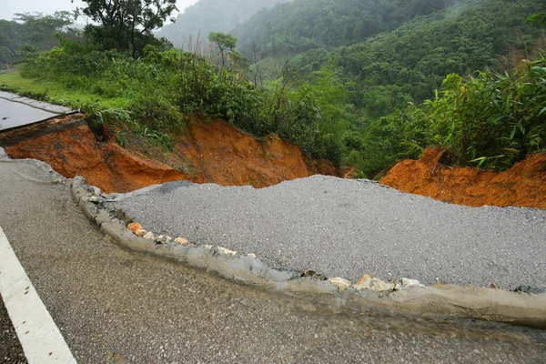 暴雨引起的山体滑坡会导致道路沥青的破碎 街上的水泥坏了 由被暴雨摧毁的山体滑坡造成的道路裂缝 — 图库照片