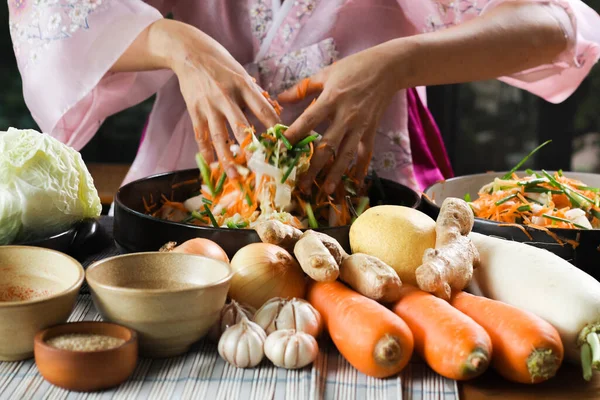 Kimchi hazırlıkları sırasında kadın ellerinin yakınlaştırılması. Kore mutfağının ünlü mezeleri, mayalanmış sebzeler, lahana, turp, baharatlı ve kokulu baharatlar elma, armut, soğan, sarımsak, zencefil ve taze soğan dahil.