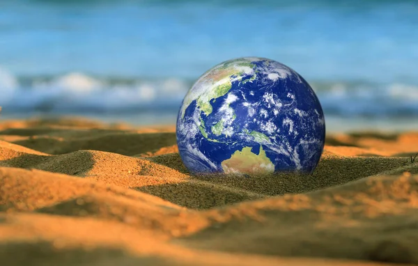 Save the Earth, Computer generated Earth like planet on a beach. Wave crushing in the background. Concept suitable for environment protection themes, save the earth etc.