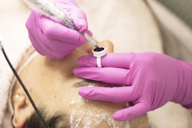 Kozmetolojist göz kapaklarına ok koyar