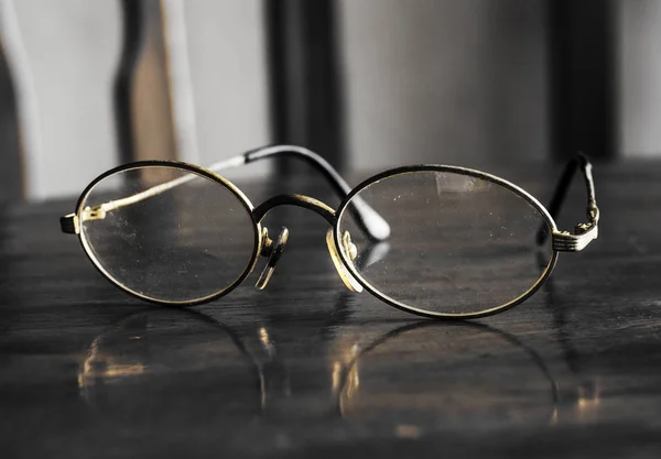 Old glasses placed on a wooden table.