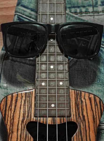 Güneş gözlüğü ve ukulele kot yerleştirilir.