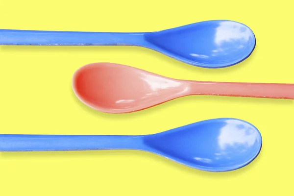 Red Blue Plastic Spoons Yellow Background — Stock Photo, Image