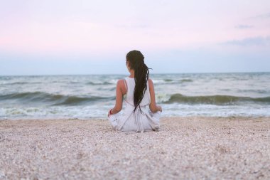 kadın dreadlocks ile yoga uygulamaları ve lotus pozisyonunda sahilde meditasyon