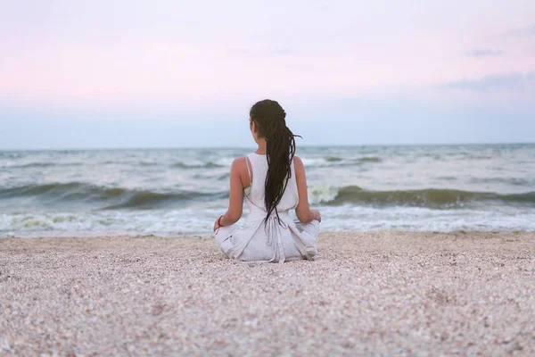 ドレッドヘアを持つ女性 ヨガや瞑想にビーチでロータスの位置 — ストック写真