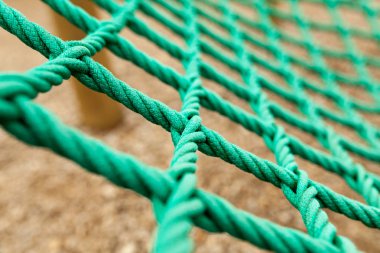 İp mesh bulanık arka plan ile. Bu yeşil ip kafes içinde bir bahçesi var. Bu yepyeni bir ip örgü değil ama eski ve bozulmaya
