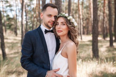 Gelin ve damat gün açık havada yaz doğa üzerinde yürüme düğününde. Gelin Çift, mutlu yeni evli kadın ve yeşil park kucaklayan adam. Sevgi dolu evlilik çift açık.