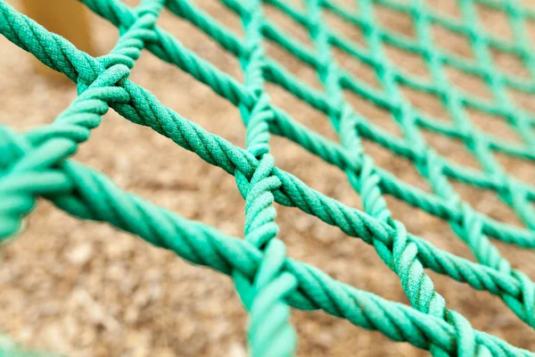 İp mesh bulanık arka plan ile. Bu yeşil ip kafes içinde bir bahçesi var. Bu yepyeni bir ip örgü değil ama eski ve bozulmaya