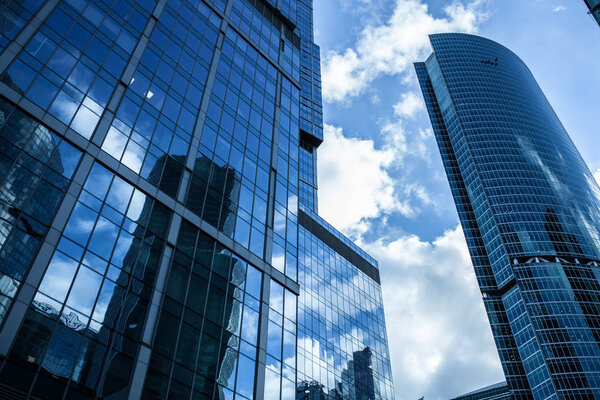 Detail blue glass modern office building background with cloud sky