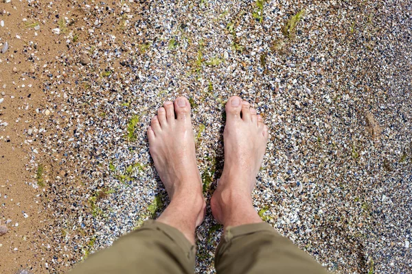 砂のビーチで水で男性の足を上から見る — ストック写真