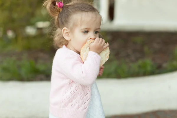 Photo soft focus de petite fille bouclée avec deux queues marchant dans la cour arrière sur l'herbe verte — Photo