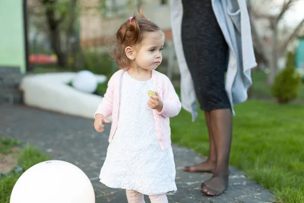 Petite fille enfant jouant sur la pelouse dans la cour avec une grande lampe électrique . — Photo