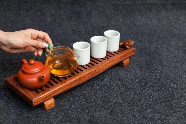 Пивоварение китайского чая в керамических gaiwan во время чайной церемонии крупным планом. Гайван и другие чайные инструменты для церемонии — стоковое фото