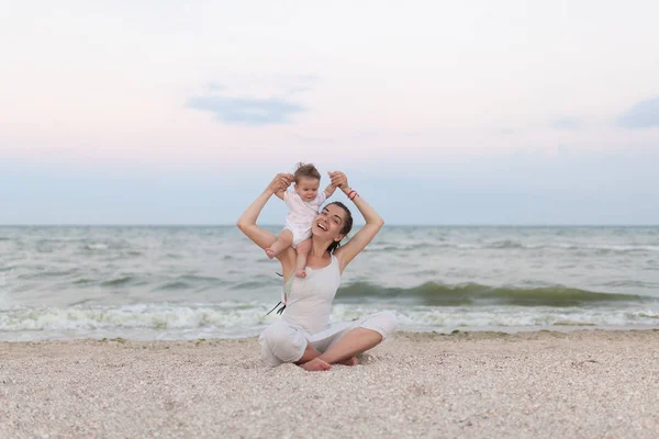 夕暮れ時のビーチで蓮華座に幸せ家族母と子娘、ヨガをやって瞑想します。 — ストック写真