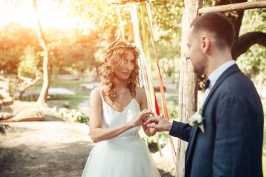 Güzellik gelin ve yakışıklı damat giyiyor birbirlerine yüzük. Düğün çift evlilik töreni üzerinde. Beyaz elbiseli güzel model kız. Takım elbiseli adam. Kadın ve erkek portre. Sevimli Bayan ve erkek