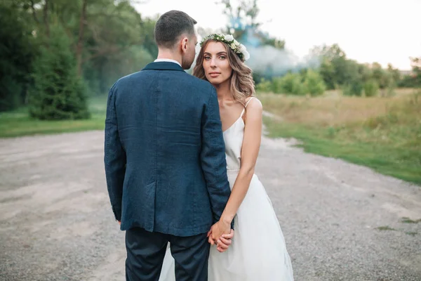 Noiva e noivo no dia do casamento andando ao ar livre na natureza de verão. Casal nupcial, mulher recém-casada feliz e homem abraçando no parque verde. Casal de amor ao ar livre. Noiva e noivo — Fotografia de Stock