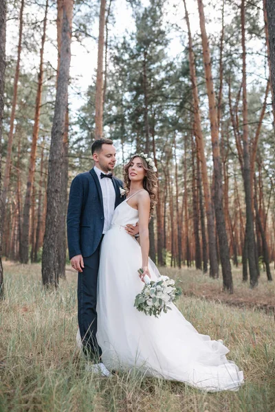 Braut und Bräutigam am Hochzeitstag beim Wandern in der Natur im Sommer. Brautpaar, glückliche frisch vermählte Frau und Mann umarmen sich im grünen Park. Liebendes Hochzeitspaar im Freien. Brautpaar — Stockfoto