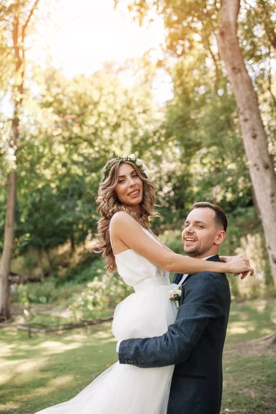 Brud og brudgom på bryllupsdag gå udendørs på sommeren naturen. Brudepar, Happy Newlywed kvinde og mand omfavne i grønne park. Kærlig bryllup par udendørs. Brud og brudgom - Stock-foto