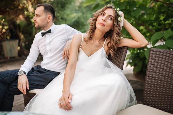 Newlywed coupe sitting on a sofa angry at each other in a middle of an argument. Young couple problem concept outdoor — Stock Photo, Image