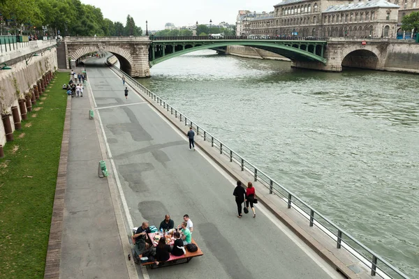 Parigi, Francia 01 giugno 2018 Un compagno di giovani beve e mangia sulle rive della Senna nel centro di Parigi. Concetto picnic in città. Festa di intrattenimento della birra — Foto Stock