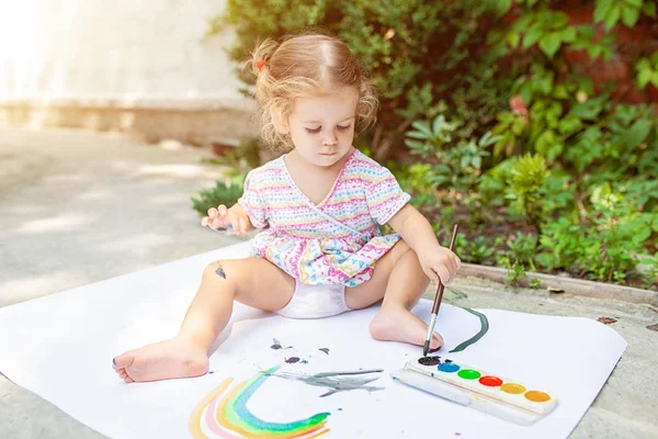 Πορτρέτο του μικρό ξανθό κορίτσι ζωγραφική, καλοκαίρι υπαίθρια. — Φωτογραφία Αρχείου