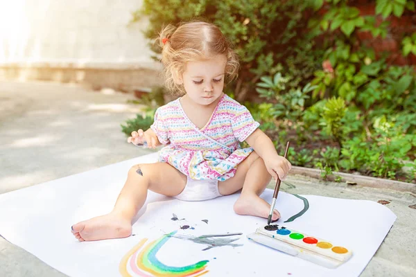 Portret van blond meisje buiten schilderen, zomer. — Stockfoto