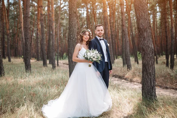 Noiva e noivo no dia do casamento andando ao ar livre na natureza de verão. Casal nupcial, mulher recém-casada feliz e homem abraçando no parque verde. Casal de amor ao ar livre. Noiva e noivo — Fotografia de Stock