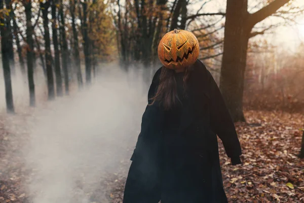 Giovane donna con una zucca di Halloween sulla testa — Foto Stock