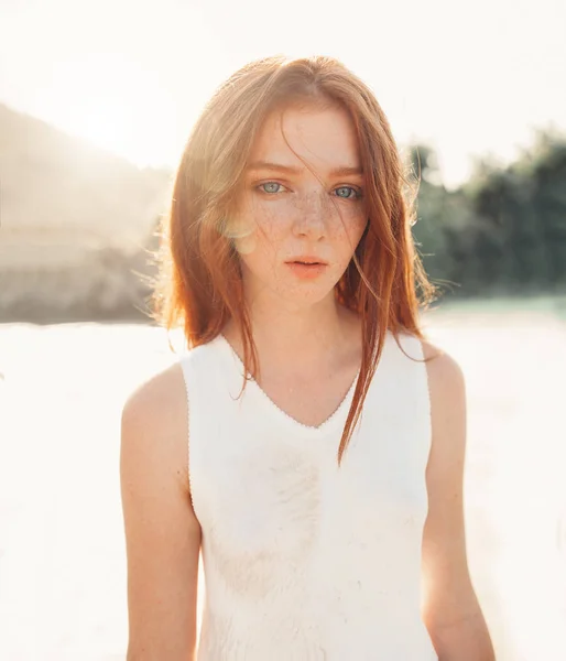 Portrait of the young pretty red-haired woman standing in the nature — Stock Photo, Image