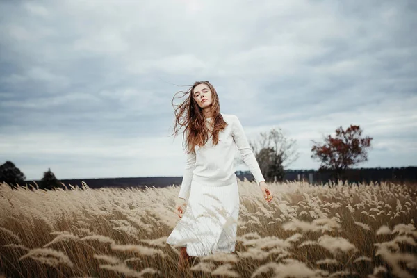 Jovem mulher bonita de pé no campo com trigo — Fotografia de Stock