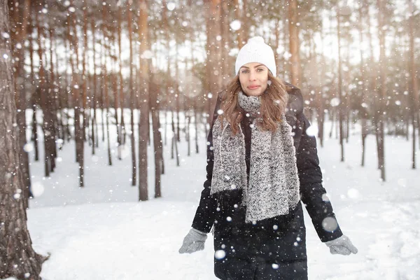 Beautiful winter portrait of young woman in the winter snowy scenery