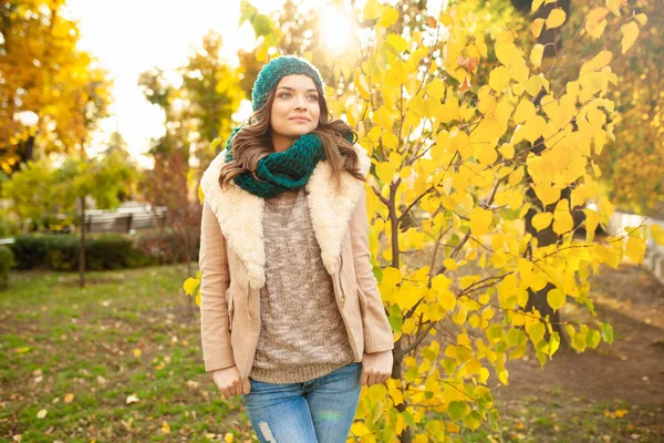 Красива молода дівчина проходить через осінній парк на тлі яскраво-кольорових листя — стокове фото