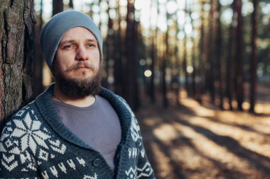 bir sakallı bir genç adam bir çam Ormanda yürür. Acımasız bir portresi sakallı adam sonbahar orman