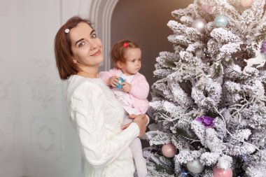 Anne küçük bir kız ile bir Noel ağacı süsleyin. Tatil için bekliyor. Noel tatili için hazırlanıyor