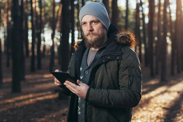 Close up portrait of adult male hiker using digital tab and looking for location during hike in nature. man on hike using digital tablet for navigation. — Stock Photo, Image