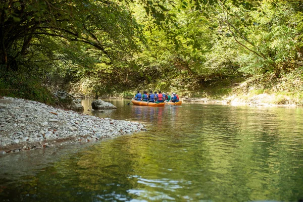 Kayaking on the river. group of people in a boat sailing along the river. Rowers with oars in a canoe. Rafting on a kayak. Leisure. — Stock Photo, Image