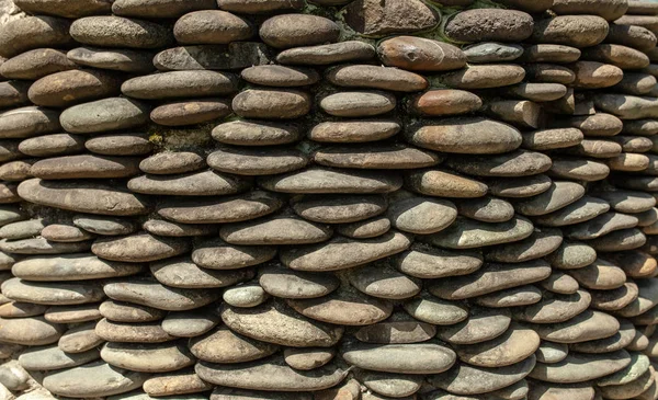 River pebble gravel round stone wall patterned for background. Gray pebbles background for home and home exterior wall and floor decoration.