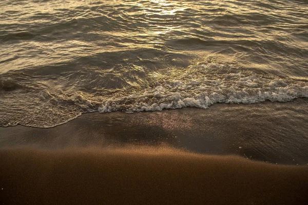 Chiudere onda spiaggia al tramonto. Sole che riflette sulla spiaggia serena. Concentrazione morbida — Foto Stock