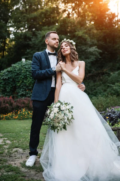 Noiva e noivo no dia do casamento andando ao ar livre na natureza de verão. Casal nupcial, mulher recém-casada feliz e homem abraçando no parque verde. Casal de amor ao ar livre. Noiva e noivo — Fotografia de Stock