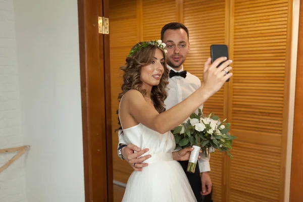 Romantiska och glad kaukasiska par i snygga kläder tar selfie på bakgrunden av vackra rum. Kärlek, relationer, dating, romantik, lycka koncept. Man och kvinna att ha roligt tillsammans. — Stockfoto