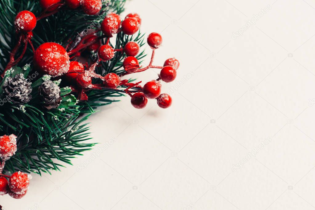 Christmas decorative wreath of holly, ivy, mistletoe, cedar and leyland leaf sprigs with red berries over white background.