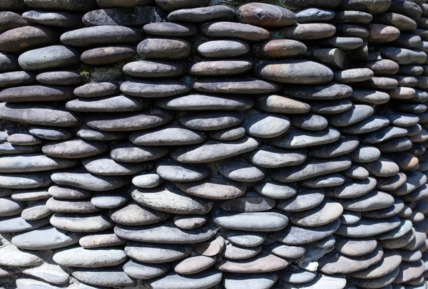 River pebble gravel round stone wall patterned for background. Gray pebbles background for home and home exterior wall and floor decoration