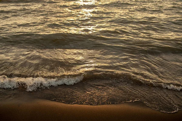 Feche a onda de praia ao pôr-do-sol. Sol refletindo na praia serena. Foco suave — Fotografia de Stock