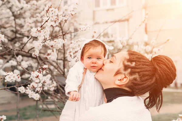 Young mother with adorable daughter in park with blossom tree. Happy mother and child — Stock Photo, Image