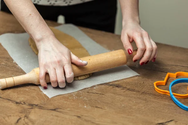 Close up de mãos femininas fazendo biscoitos de massa fresca em casa — Fotografia de Stock