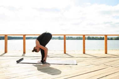 Güzel atletik kız doğada germe yapıyor. Fitness kadının yoga egzersizleri yapması