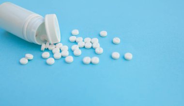 Hapları ve pill şişe mavi kağıt arka plan üzerinde