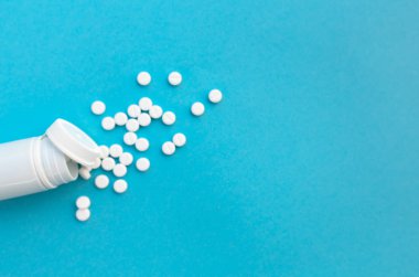 Hapları ve pill şişe mavi kağıt arka plan üzerinde